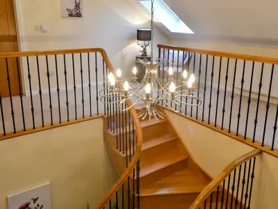 a staircase with a chandelier in a house at Wheatfield House in Kilmaurs