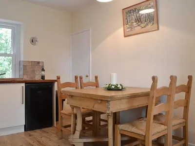 a kitchen with a wooden table and chairs at Blaithwaite Cottage in Blencogo