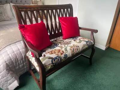 a wooden bench with two red pillows on it at Rockhill Guest House in Moffat