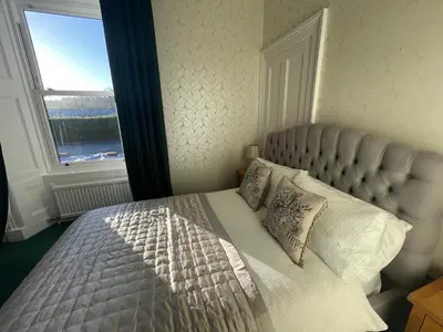 a bedroom with a bed with a large window at Rockhill Guest House in Moffat