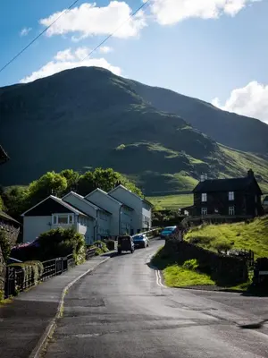 a street with houses and cars on a mountain at YHA Helvellyn in Glenridding