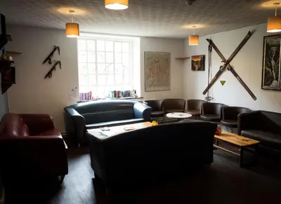 a living room with leather furniture and a window at YHA Helvellyn in Glenridding