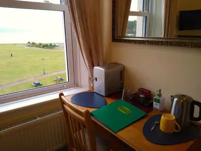 a desk with a window and a computer on it at Green View Guest House in Silloth