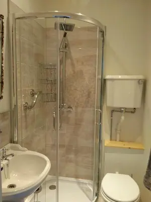 a bathroom with a shower and a toilet and a sink at Green View Guest House in Silloth