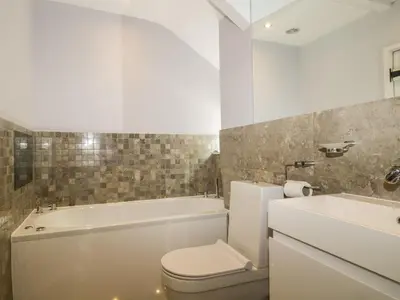 a bathroom with a tub and a toilet and a sink at Stair Cottage in Keswick