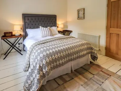 a bedroom with a large bed with a comforter at Beck Steps 1 in Grasmere