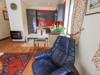 a living room with a leather chair and a table at Stonegarth Cottage in Ambleside