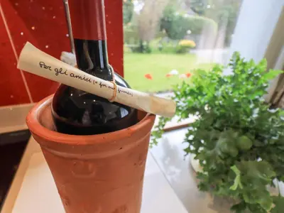 a bottle of wine in a vase with a cigarette at Stonegarth Cottage in Ambleside