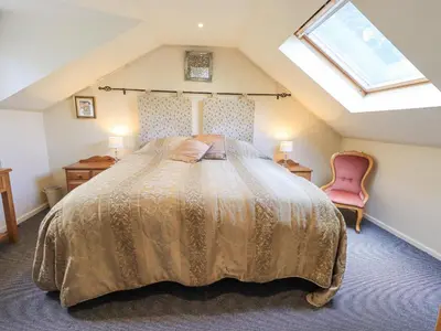 a bedroom with a large bed in a attic at Stonegarth Mews in Ambleside