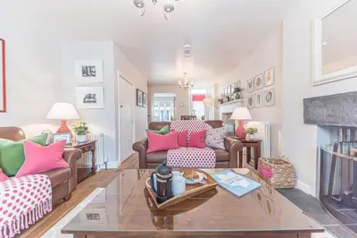 a living room with two couches and a table at Poppy's Cottage in Ambleside