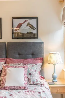 a bedroom with a bed with a picture on the wall at Poppy's Cottage in Ambleside