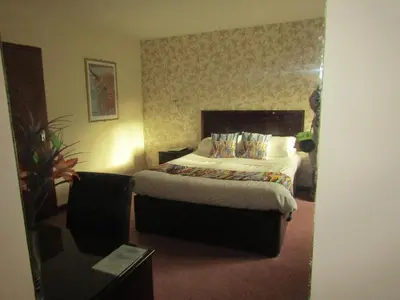 a hotel room with a bed and a table at Hunters Lodge Hotel in Gretna Green