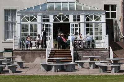 a group of people sitting at tables outside a building at Cally Palace Hotel & Golf Course in Gatehouse of Fleet