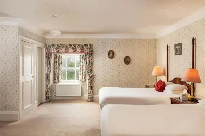 a bedroom with two beds and a window at Cally Palace Hotel & Golf Course in Gatehouse of Fleet