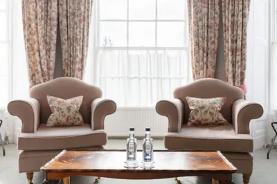 two chairs and two bottles on a coffee table at Cally Palace Hotel & Golf Course in Gatehouse of Fleet
