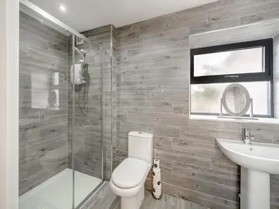 a bathroom with a toilet and a sink and a shower at North Plain Barn in Bowness-on-Solway
