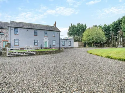 an image of a house with a gravel driveway at North Plain Barn in Bowness-on-Solway