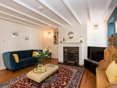 a living room with a blue couch and a fireplace at High Street in Kirkcudbright