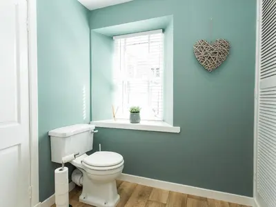 a bathroom with a toilet and a heart window at High Street in Kirkcudbright