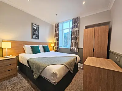 a hotel room with a bed and a window at Derwent Manor Apartments in Keswick