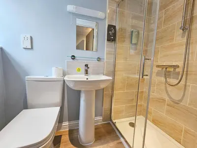 a bathroom with a toilet and a sink and a shower at Derwent Manor Apartments in Keswick
