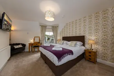 a bedroom with a large bed and a desk at Portland House in Keswick