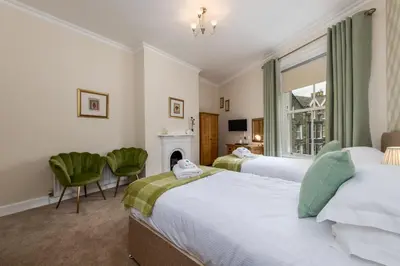 a hotel room with two beds and a fireplace at Portland House in Keswick