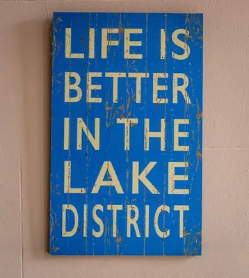 a blue sign that says life is better in the lake district at Portland House in Keswick