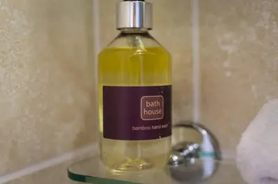 a bottle of soap sitting on a glass shelf at Portland House in Keswick