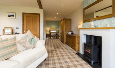 a living room with a couch and a fireplace at The Inn at Ravenglass in Ravenglass