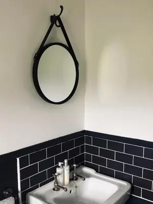 a bathroom with a sink and a mirror on the wall at Woodend Cottage in Dumfries