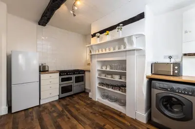 a kitchen with a refrigerator and a washer and dryer at Muncaster Cottages in Ravenglass