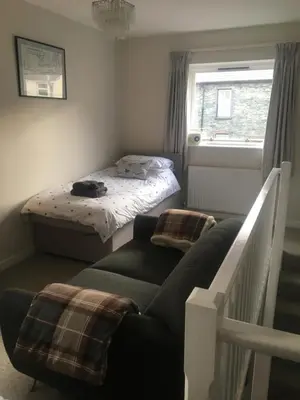 a small bedroom with a bed and a couch at Self-Contained Accommodation for 2 in Keswick