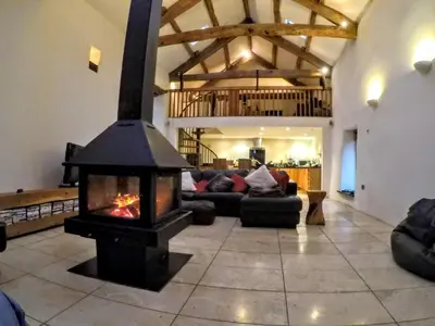 a living room with a fireplace in the middle at The Lazy Fish in Cockermouth