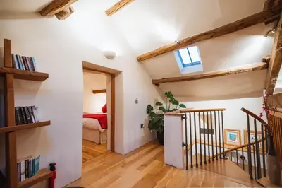 a room with white walls and wooden floors and a staircase at The Lazy Fish in Cockermouth