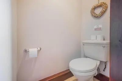 a bathroom with a toilet and a wreath on the wall at Big White House in Cockermouth