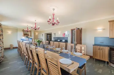 a dining room with a long table and chairs at Big White House in Cockermouth