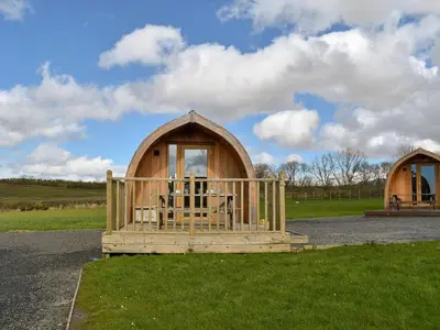 a wooden cabin with a porch in a field at Stainton-Uk1395 in Corney