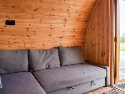 a couch in a room with a wooden wall at Barn Scar-Uk1394 in Corney