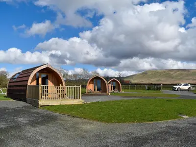 a couple of small huts in a parking lot at Manx View-Uk1396 in Corney