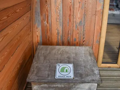 a bench in a room with a sign on it at Manx View-Uk1396 in Corney