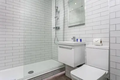 a white bathroom with a toilet and a sink at Cairn Suite - Donnini Apartments in Ayr