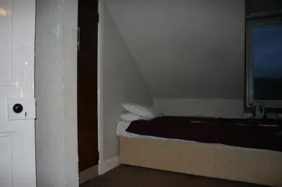 a small bed in a room with a window at Royal Hotel in Girvan