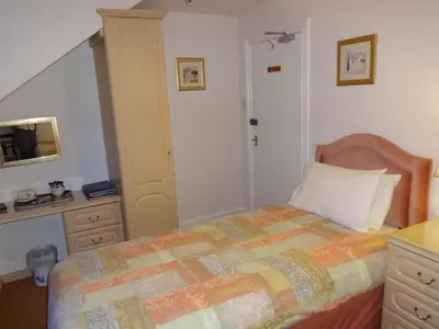 a bedroom with a bed and a dresser at Aberdour Guest House in Dumfries