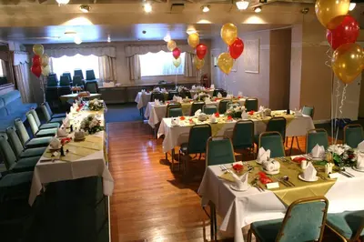a banquet hall with white tables and green chairs and balloons at Aberdour Guest House in Dumfries