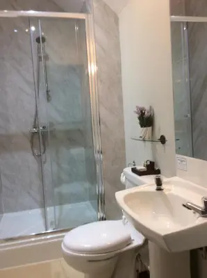 a bathroom with a shower and a toilet and a sink at Eskdale Hotel in Langholm