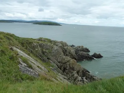 a view of a large body of water with rocks at Sunset Retreat Lodge with Hot Tub in Carsethorn