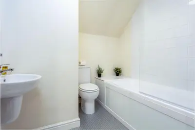 a white bathroom with a toilet and a sink at Elliot Suite No9 - Donnini Apartments in Ayr