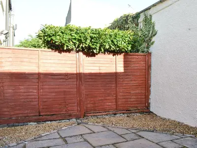 a wooden fence with plants on top of it at Alan's Cottage in Cockermouth