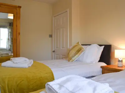 a bedroom with two beds with towels on them at Alan's Cottage in Cockermouth